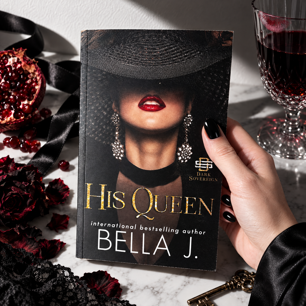 Hand holding a signed paperback of His Queen by Bella J., model cover, Nicoli trilogy book 2