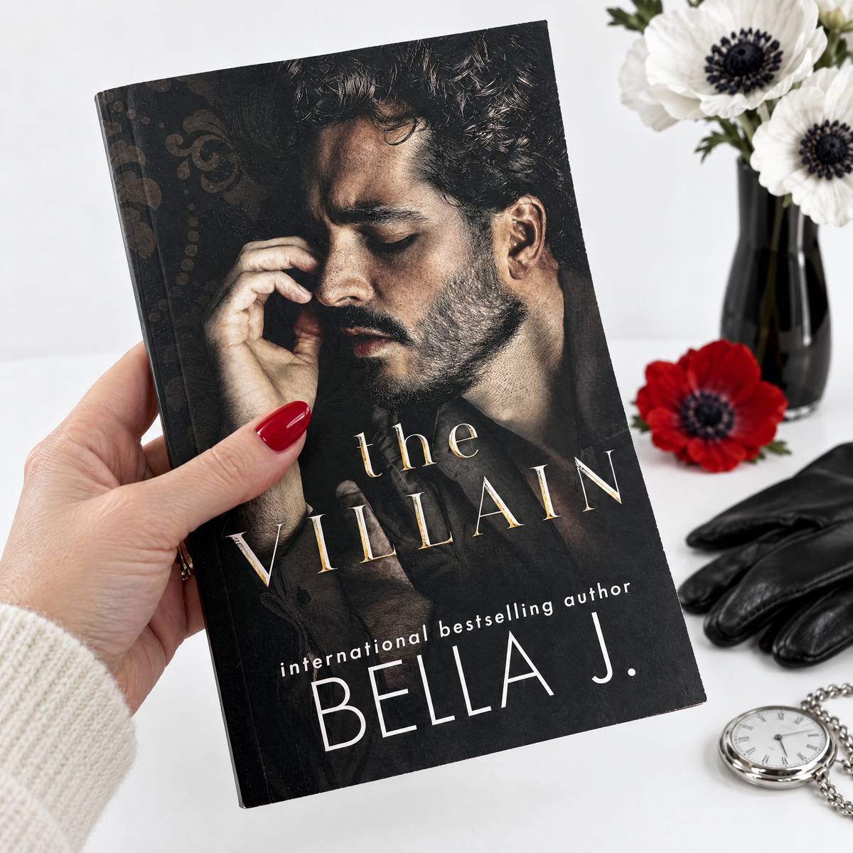 Hand holding a signed copy of The Villain by Bella J., dark stalker romance standalone
